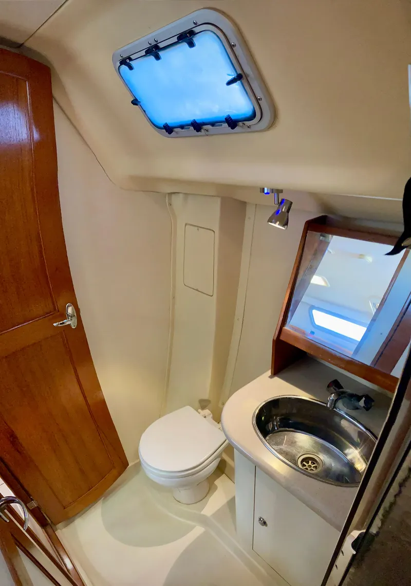 Slide: The Image of Compact bathroom in 2005 Hunter 41 AC yacht with toilet, sink, and porthole window. - 34
