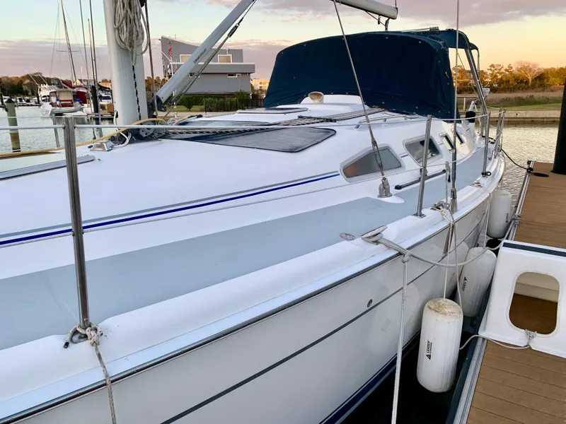 Slide: The Image of Sailboat docked at marina, 2005 Hunter 41 AC model, with blue canopy and white hull. - 7