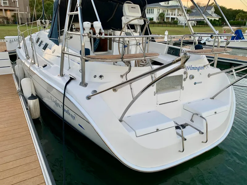 Slide: The Image of 2005 Hunter 41 AC sailboat docked, featuring a spacious deck and sleek design. - 8