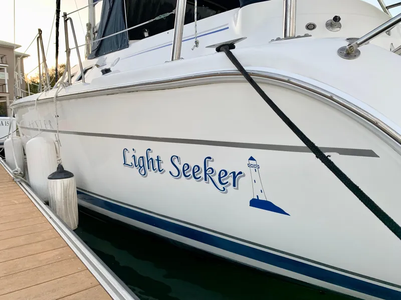 Slide: The Image of 2005 Hunter 41 AC sailboat "Light Seeker" docked, featuring a lighthouse graphic. - 9