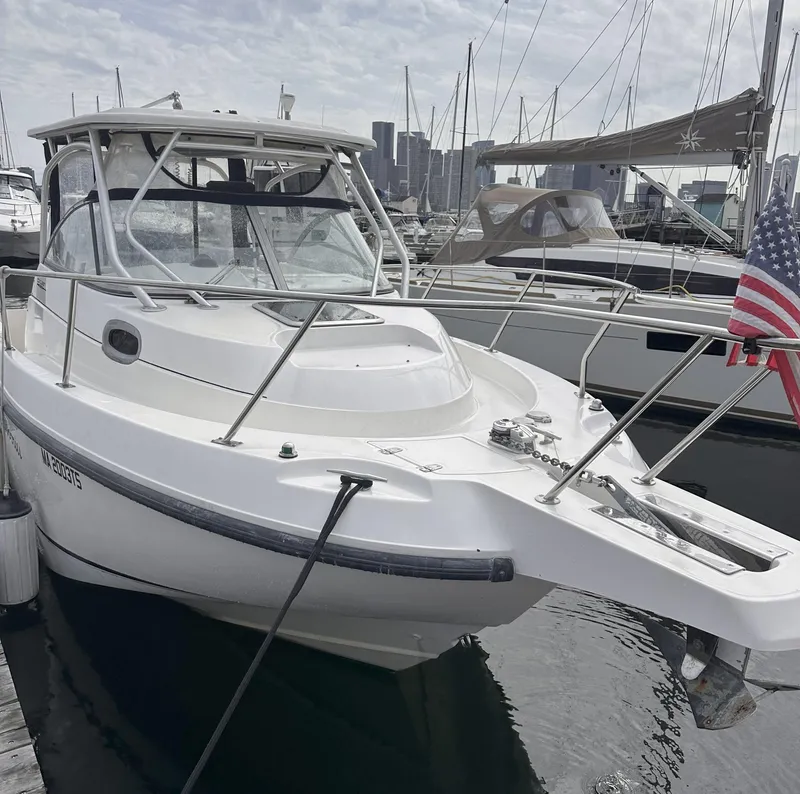 Slide: The Image of 2003 Boston Whaler 255 Conquest boat docked at marina with American flag. - 3