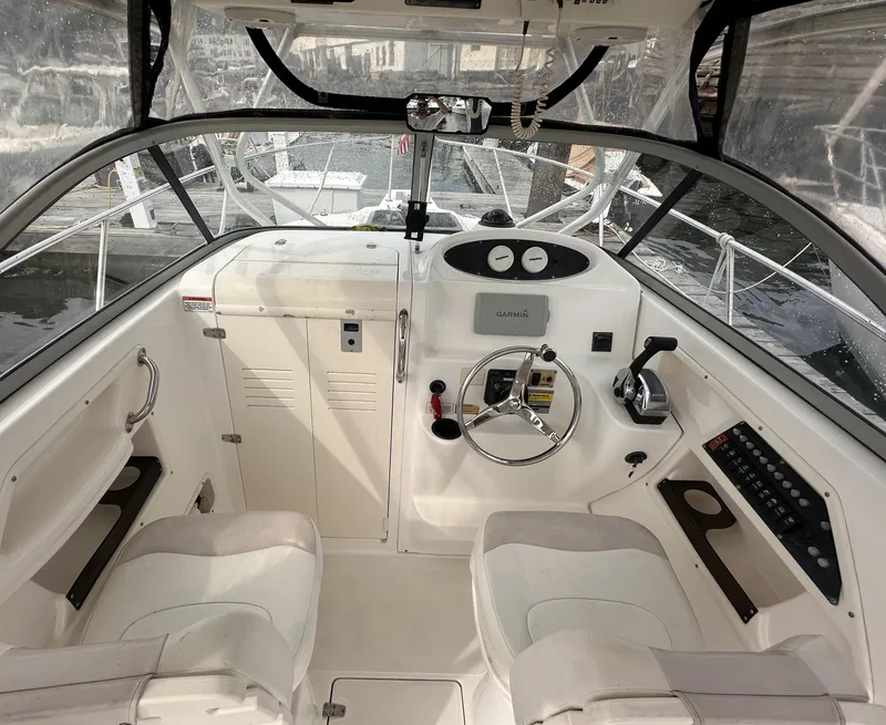 Slide: The Image of 2003 Boston Whaler 255 Conquest boat cockpit with steering wheel and navigation controls. - 4