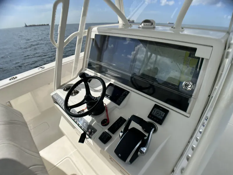 Slide: The Image of 2022 SeaVee 390z Center Console boat helm with steering wheel and navigation controls. - 10
