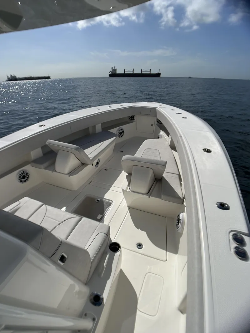 Slide: The Image of 2022 SeaVee 390z Center Console boat on open water with cargo ships in the background. - 16