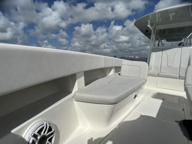 Slide: The Image of 2022 SeaVee 390z Center Console boat with cushioned seating and speaker, under a partly cloudy sky. - 31