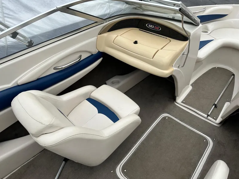 Slide: The Image of Interior of a 2002 Larson SEI 210 boat with white and blue seating. - 2