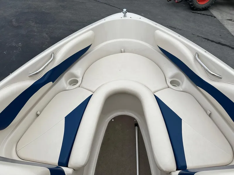 Slide: The Image of 2002 Larson SEI 210 boat interior with white and blue cushioned seating. - 3