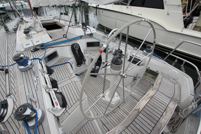 Slide: The Image of 1983 Baltic 38DP sailboat cockpit with steering wheel and winches, docked at marina. - 13
