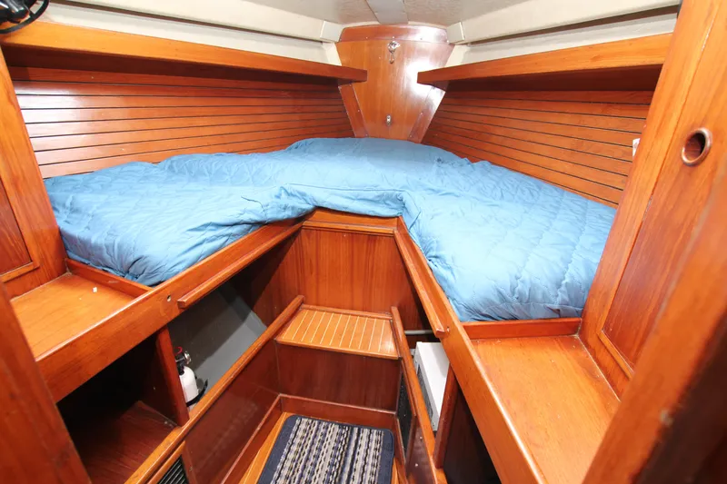 Slide: The Image of Cozy cabin interior of 1983 Baltic 38DP sailboat with wooden finish and blue bedding. - 14