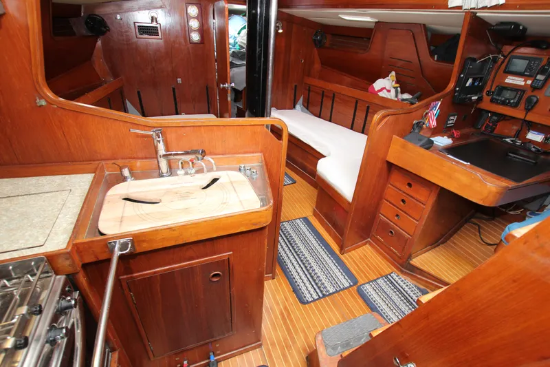 Slide: The Image of Interior of 1983 Baltic 38DP sailboat with wooden cabinetry and compact kitchen area. - 19