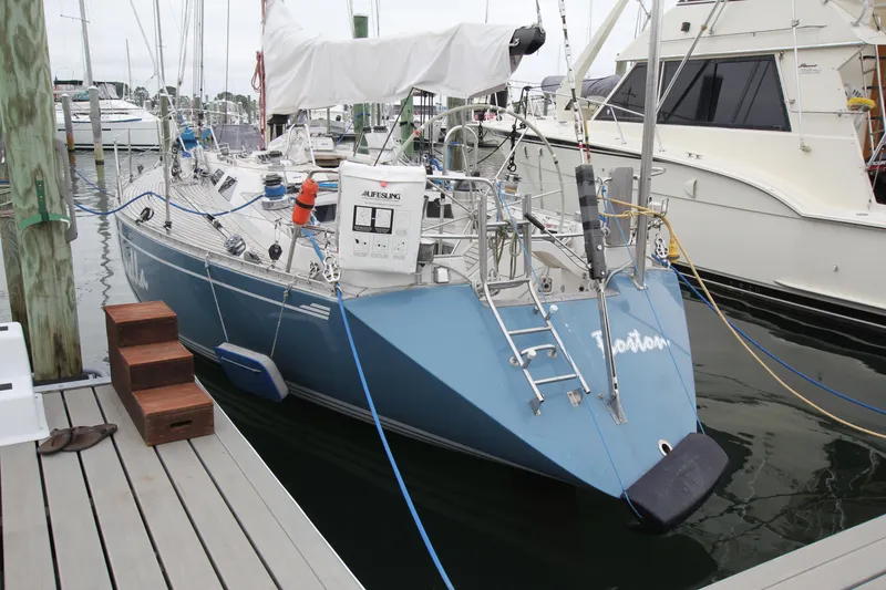 Slide: The Image of 1983 Baltic 38DP sailboat docked at marina, featuring blue hull and deck equipment. - 2