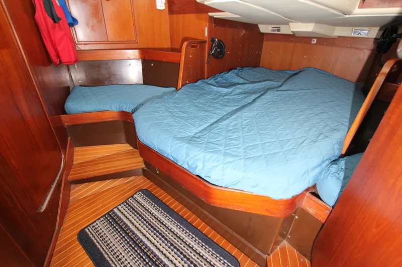 Slide: The Image of Cozy cabin interior of 1983 Baltic 38DP sailboat with blue bedding and wooden finish. - 24