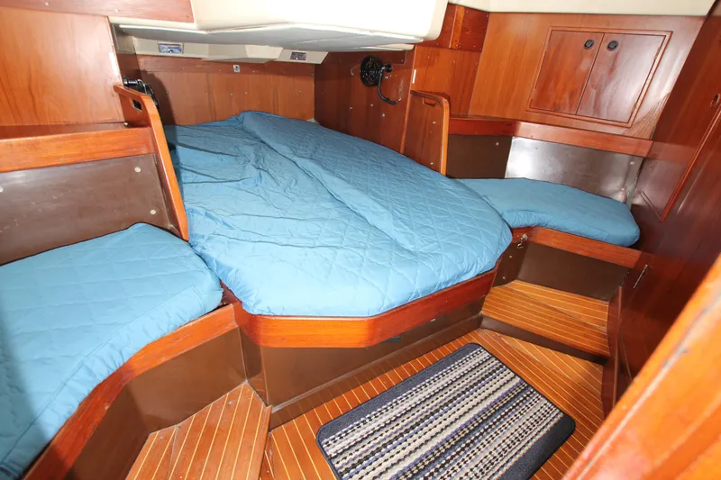 Slide: The Image of Cozy cabin interior of 1983 Baltic 38DP yacht with blue bedding and wooden finish. - 25