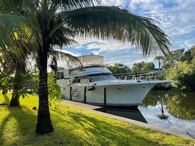 The Image of Carver Californian 52 yacht docked by palm trees, reflecting on calm water, 1990 model. - 0
