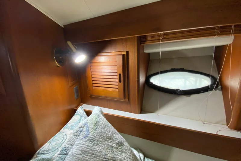 Slide: The Image of Cozy cabin interior of 1990 Californian 52 yacht with wood paneling and porthole window. - 78