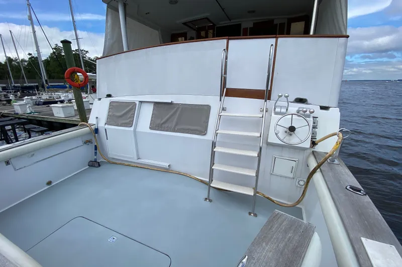 Slide: The Image of 1990 Californian 52 yacht deck with ladder, steering wheel, and marina view. - 10