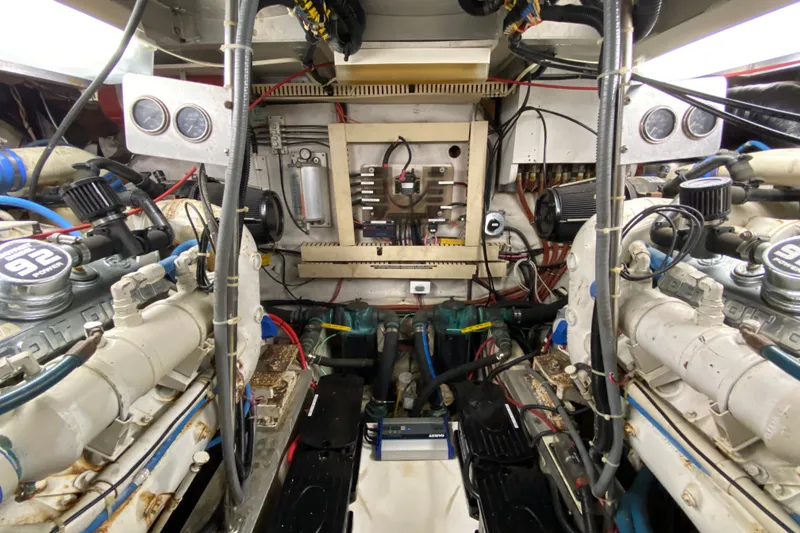 Slide: The Image of Engine room of a 1990 Californian 52 yacht, showcasing dual engines and complex wiring. - 38
