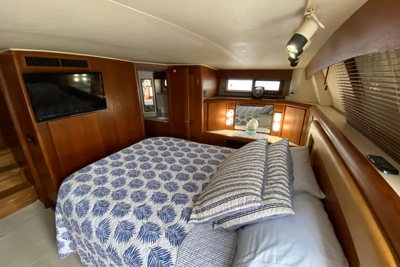 Slide: The Image of Luxurious bedroom interior of 1990 Californian 52 yacht with cozy bedding and wooden accents. - 42