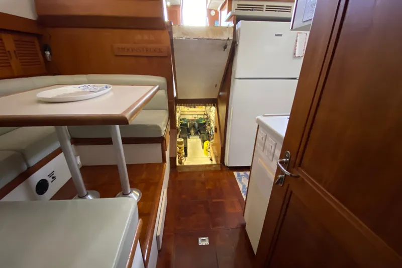 Slide: The Image of Interior of a 1990 Californian 52 yacht, featuring dining area and kitchen. - 48