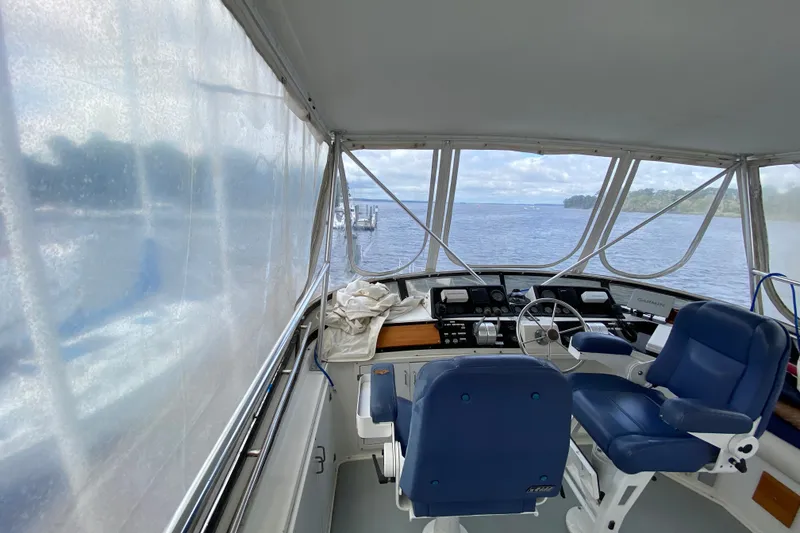 Slide: The Image of Interior view of 1990 Californian 52 yacht cockpit with blue seating and scenic water view. - 23