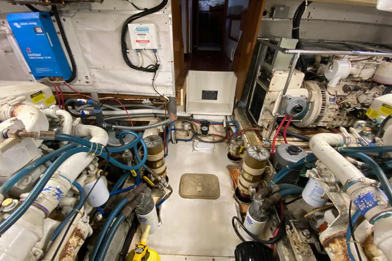 Slide: The Image of Engine room of a 1990 Californian 52 yacht, featuring complex machinery and wiring. - 34