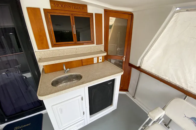 Slide: The Image of Interior of a 1990 Californian 52 yacht with sink, cabinets, and wooden door. - 24