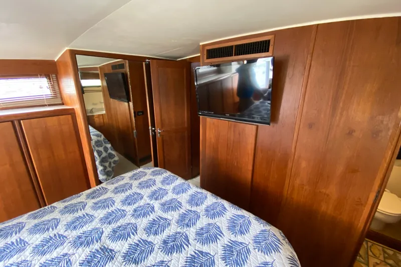 Slide: The Image of Cozy bedroom in 1990 Californian 52 yacht with wood paneling and TV. - 53