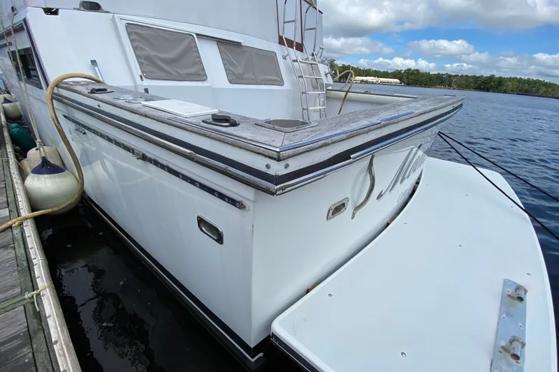Slide: The Image of 1990 Californian 52 yacht docked, featuring sleek design and spacious deck area. - 9