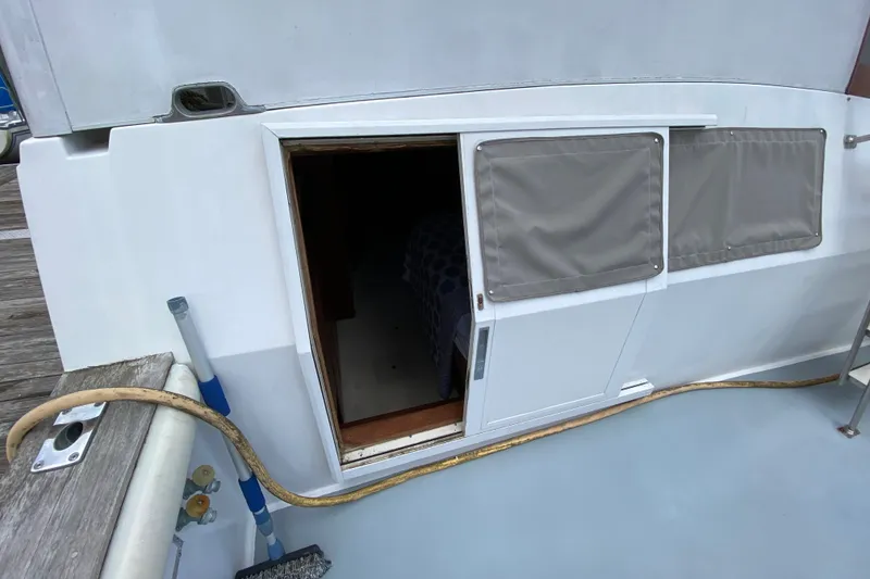 Slide: The Image of 1990 Californian 52 yacht cabin entrance with sliding door and covered windows. - 46