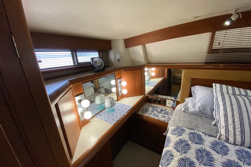 Slide: The Image of Cozy 1990 Californian 52 yacht cabin with wood accents and nautical bedding. - 51