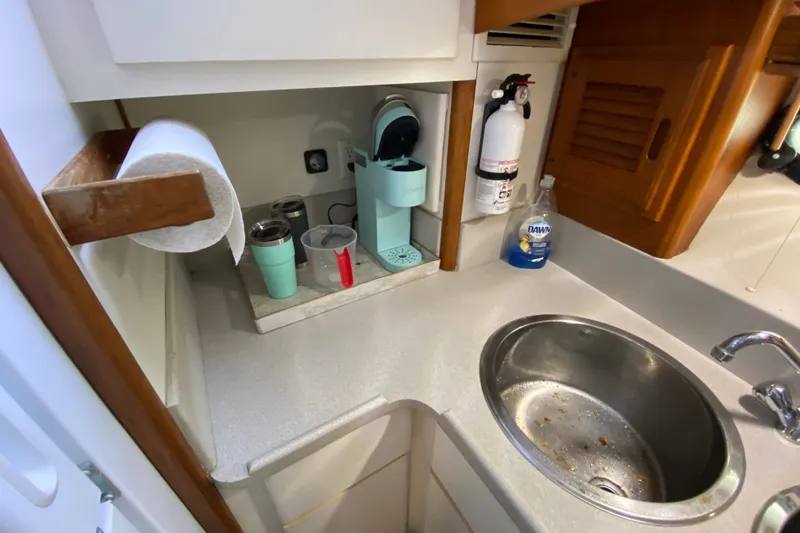 Slide: The Image of Compact kitchen area in a 1990 Californian 52 yacht with sink and coffee maker. - 69