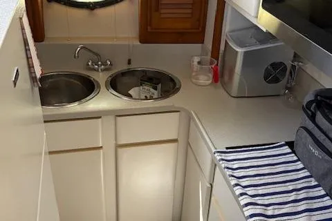 Slide: The Image of Compact kitchen area in a 1990 Carver Californian 52 yacht with dual sinks and modern appliances. - 9