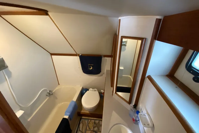 Slide: The Image of Bathroom interior of 1990 Californian 52 yacht with bathtub, toilet, and mirror. - 49