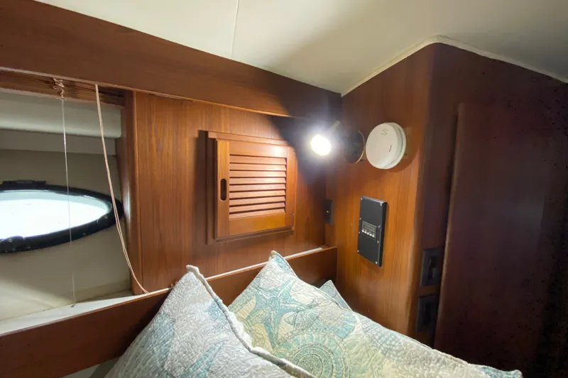 Slide: The Image of Cozy cabin interior of 1990 Californian 52 yacht with wooden paneling and decorative pillows. - 73