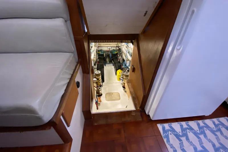 Slide: The Image of Engine room access in 1990 Californian 52 yacht, featuring wooden interior and seating. - 44