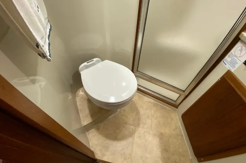 Slide: The Image of Compact bathroom in a 1990 Californian 52 yacht, featuring a toilet and shower. - 76
