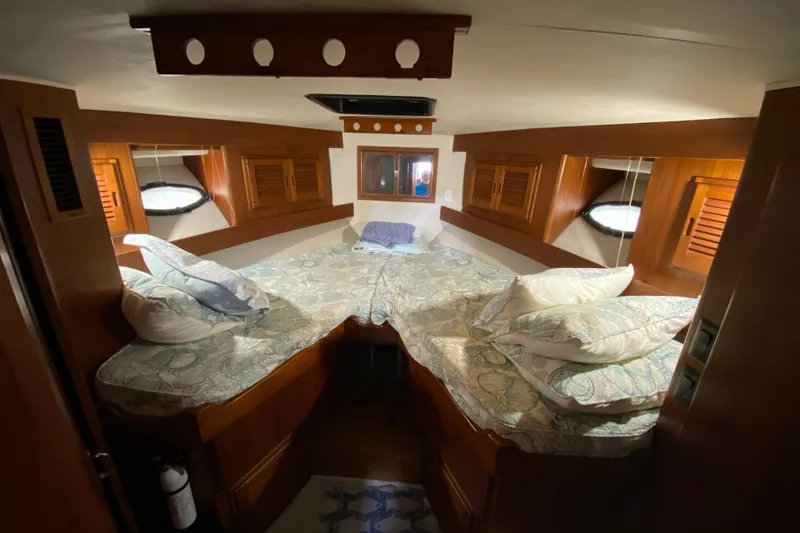 Slide: The Image of Cozy cabin interior of a 1990 Californian 52 yacht with wooden accents and bedding. - 80