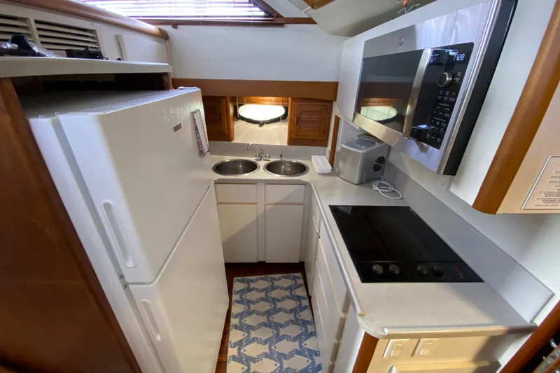 Slide: The Image of Compact kitchen in a 1990 Californian 52 yacht with modern appliances and dual sinks. - 68