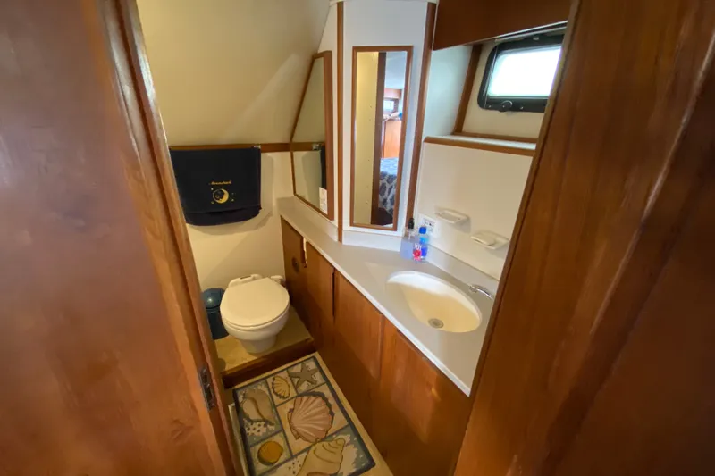 Slide: The Image of 1990 Californian 52 yacht bathroom with wooden cabinetry, sink, and toilet. - 56