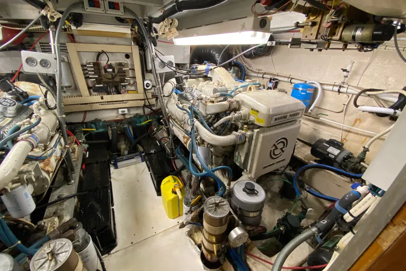 Slide: The Image of Engine room of a 1990 Californian 52 yacht, featuring complex machinery and wiring. - 36