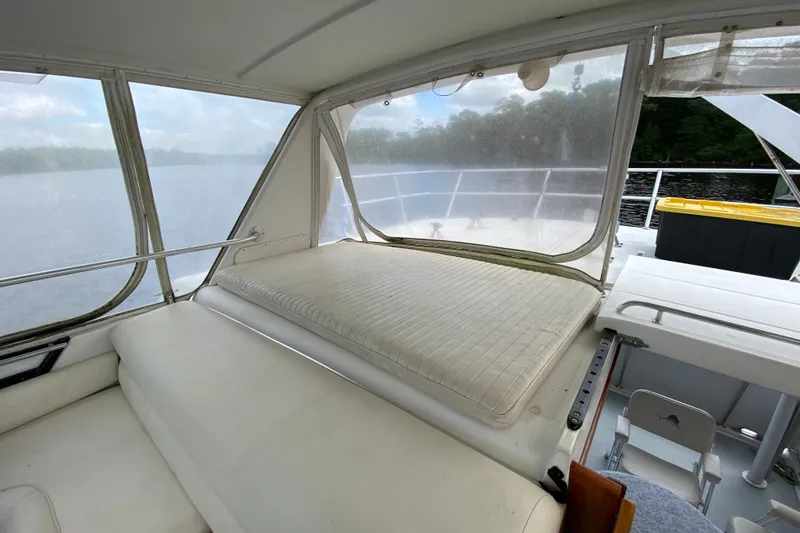 Slide: The Image of Interior view of a 1990 Californian 52 yacht with white seating and large windows. - 22
