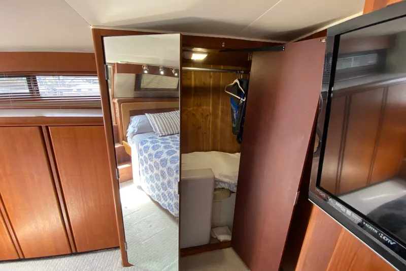 Slide: The Image of Luxurious 1990 Californian 52 yacht interior with wooden cabinetry and cozy bedroom. - 43