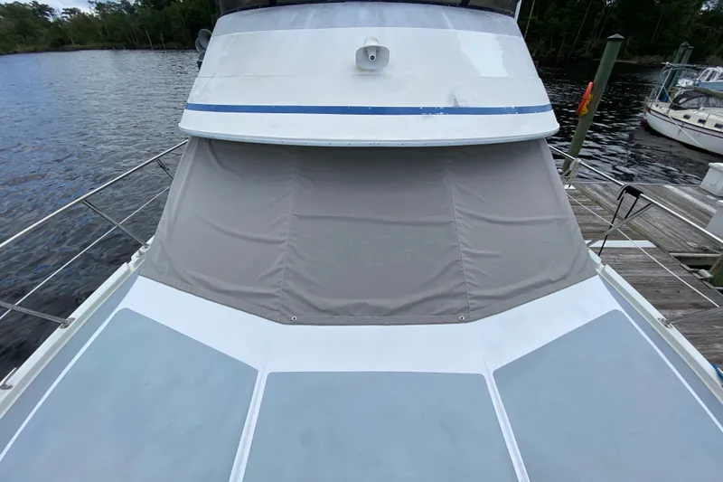 Slide: The Image of 1990 Californian 52 yacht docked, featuring a covered deck and sleek design. - 17