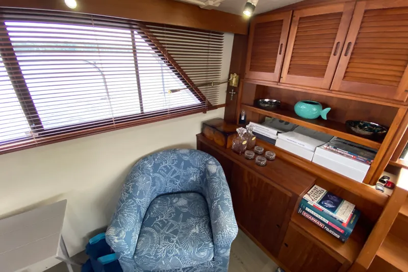 Slide: The Image of Cozy interior of a 1990 Californian 52 yacht with blue armchair and wooden cabinets. - 61