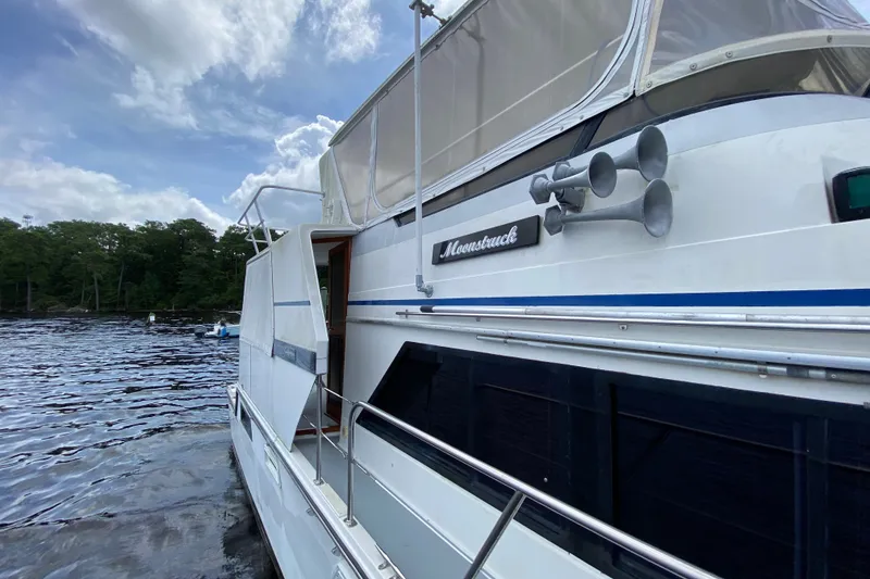 Slide: The Image of 1990 Californian 52 yacht named Moonstruck on a serene lake with cloudy sky. - 18