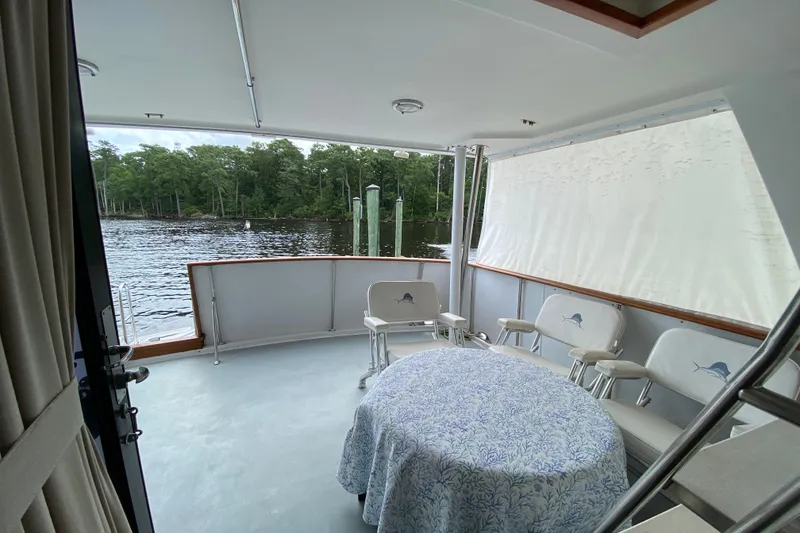 Slide: The Image of Covered deck of 1990 Californian 52 yacht with chairs and table, overlooking water. - 30