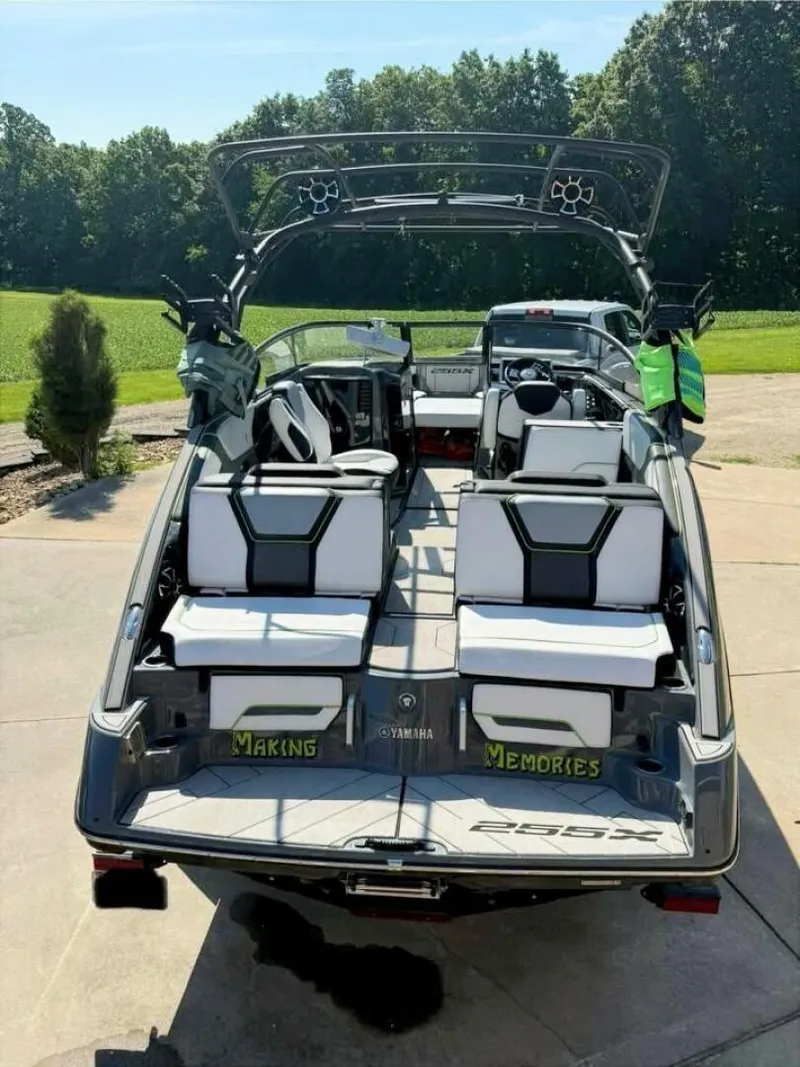 Slide: The Image of 2021 Yamaha Boats 255XD with sleek interior, parked outdoors on a sunny day. - 1