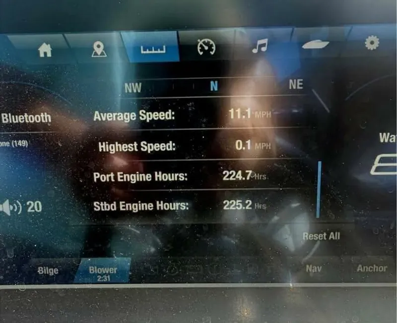 Slide: The Image of 2021 Yamaha Boats 255XD in a showroom, black with green accents, on a trailer. - 5