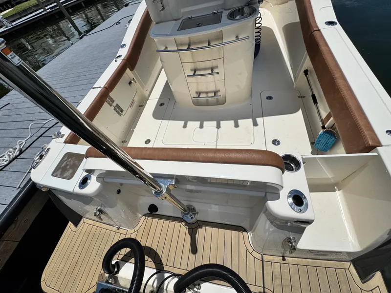 Slide: The Image of 2024 Scout 277 LXF boat interior with brown seating and fishing rod holders. - 12