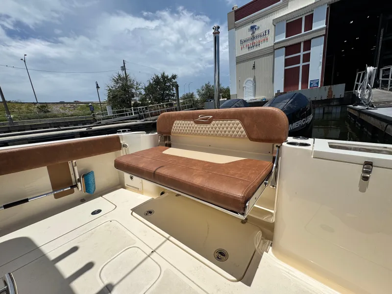 Slide: The Image of 2024 Scout 277 LXF boat with tan seating at a marina. - 14